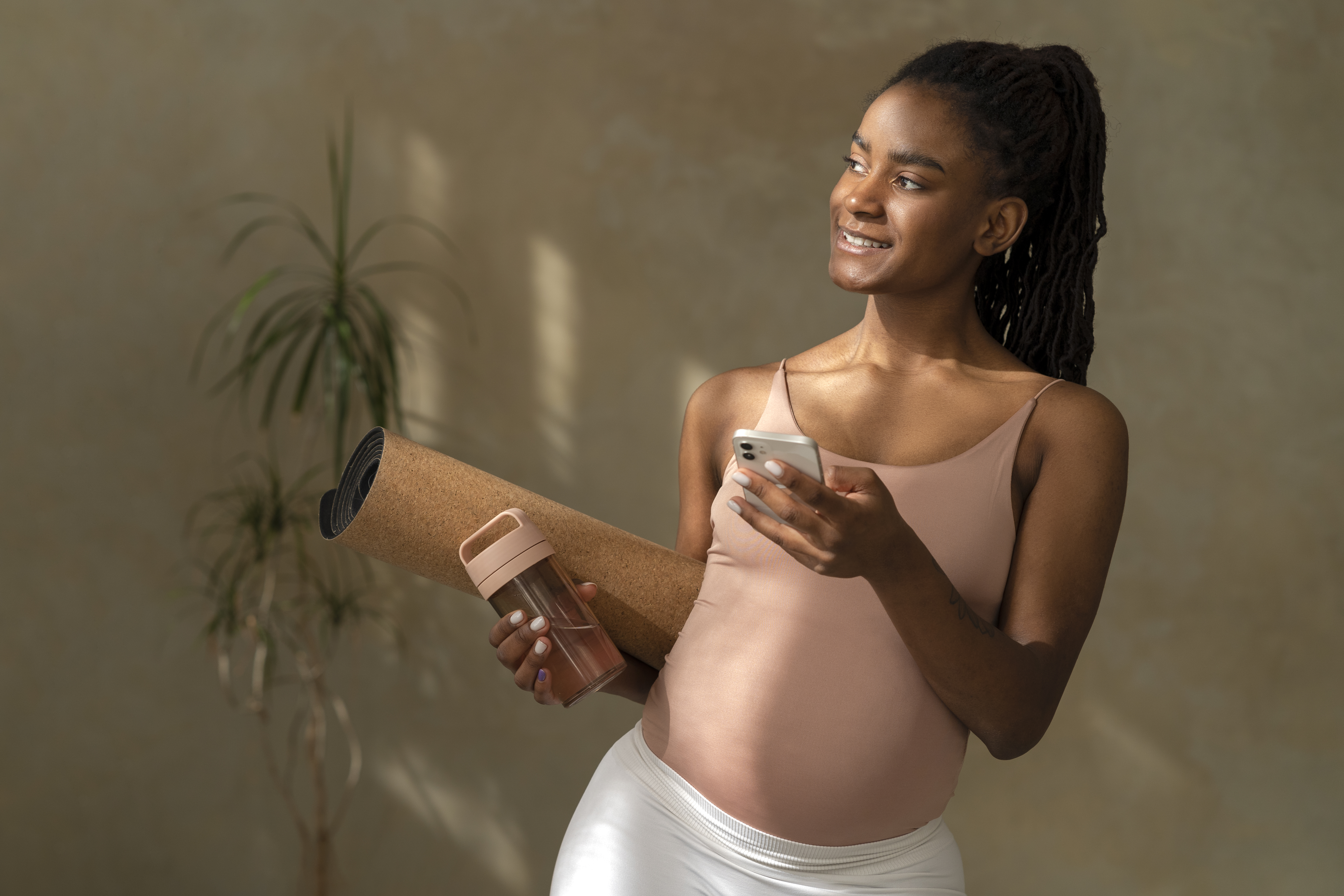 Medium shot pregnant woman holding yoga mat