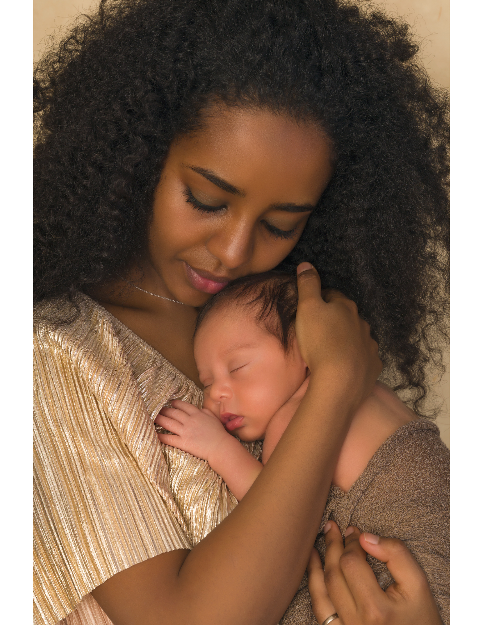 A beautiful Black woman lovingly cradles her newborn son in her arms, showcasing a tender moment of motherhood.